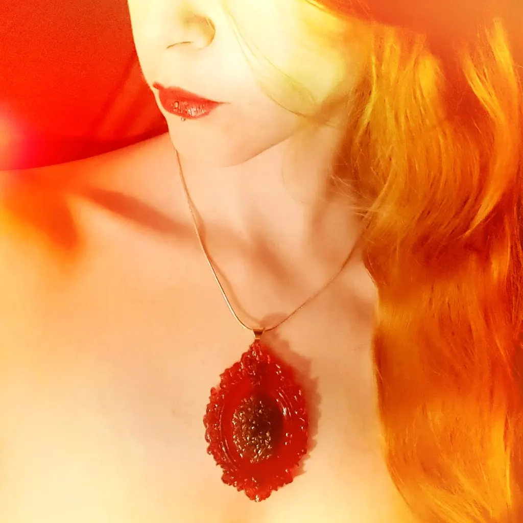 A red resin pendant, worn
